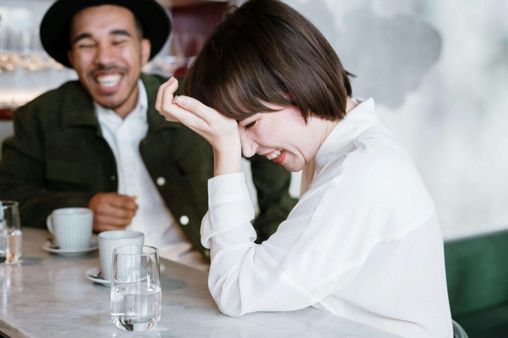 Couples smiling while siting down to coffee and showing signs of communicating well.