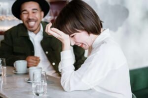 Couples smiling while siting down to coffee and showing signs of communicating well. 