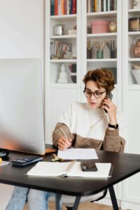 Person taking notes about couples counseling as she talks to therapist during a free discovery call