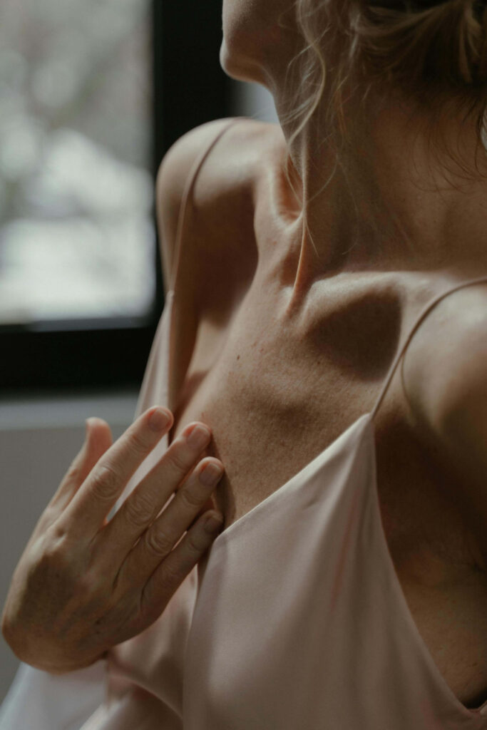 A woman rests with eyes gently closed, tuning inward, a moment of connection during a Brainspotting intensive with a therapist near them.