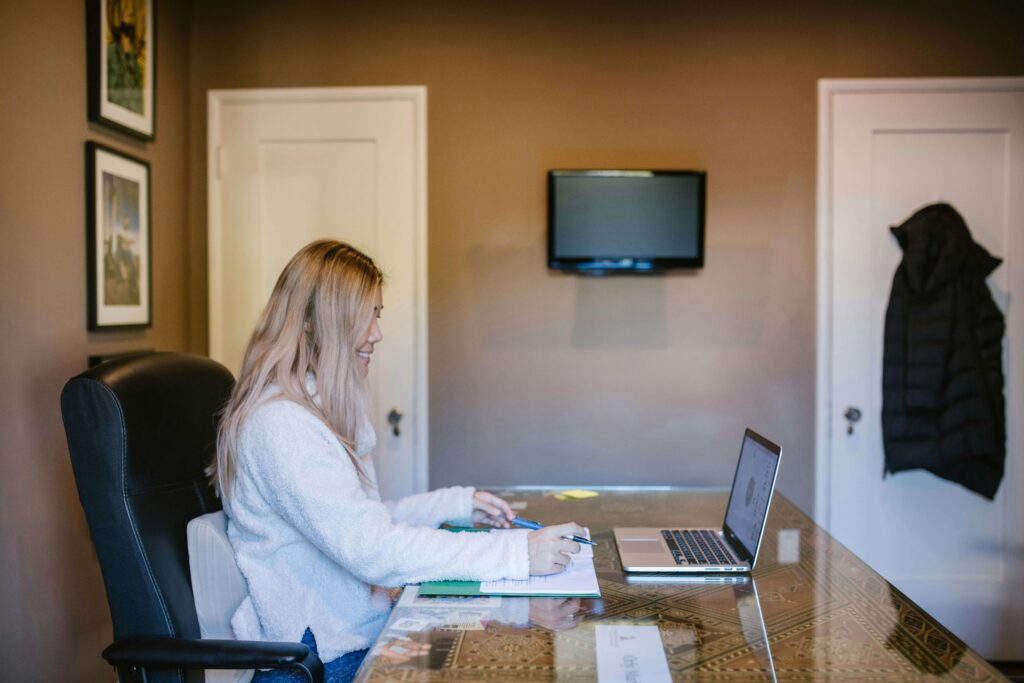 Woman in a calm home space attending an online therapy session in Colorado on her laptop.