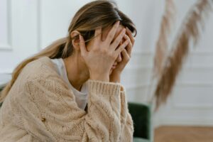 Woman with head in hands becoming aware of anxiety through the help of counseling.