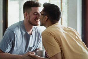 Gay couples looking at each other lovingly as they've learned to work through conflict with marriage therapy in Colorado.