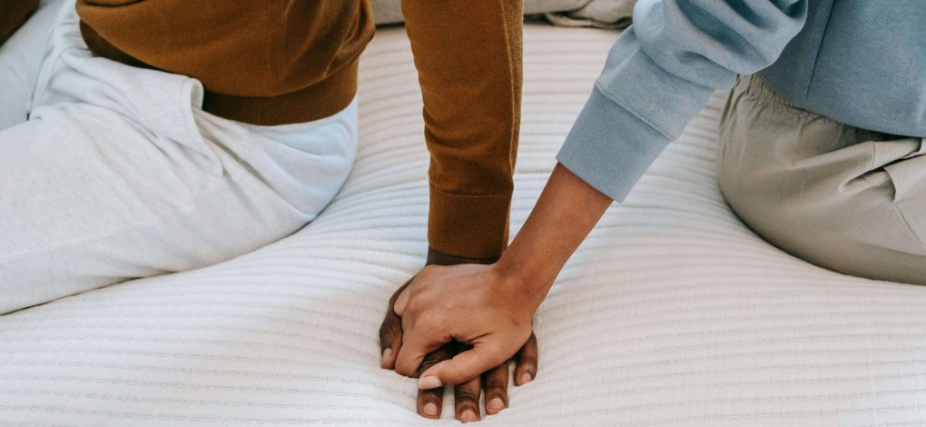 Zoomed in picture on couples holding hands as they prepare to reach out for couples counseling